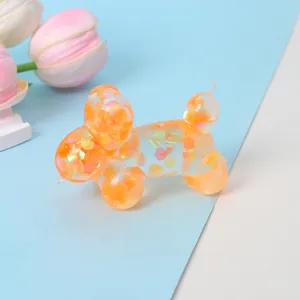Close-up of a transparent orange balloon dog squishy toy with iridescent sequins.