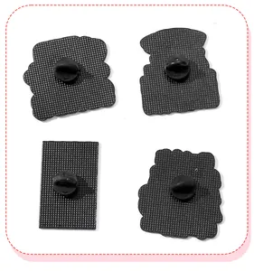Detailed macro view showing the textured back and black rubber clutches of the enamel pins.