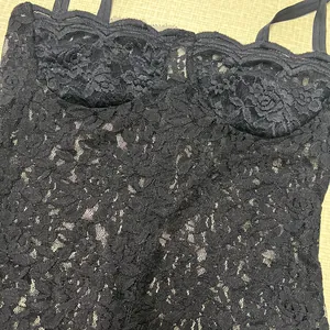 Close-up of sexy black lace bustier dress with floral patterns and spaghetti straps