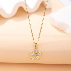 Detailed view of an elegant gold flower pendant necklace with pavé set clear stones.