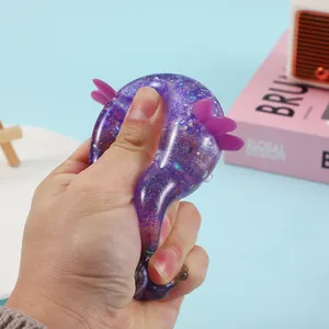 Hand squeezing a purple glittery axolotl squishy toy for effective stress relief