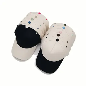 Stacks of two-tone 5-panel cotton baseball caps with decorative colorful buttons