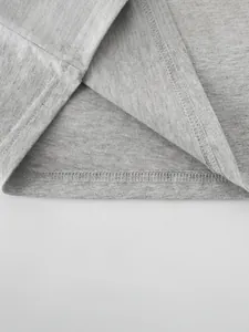 Detailed macro view of grey cotton t-shirt hem with professional double-stitched seams
