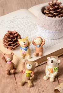 Vue détaillée de cinq figurines d'animaux en résine sur un support de livre ancien