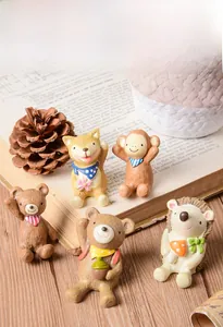 Vue détaillée de cinq figurines d'animaux en résine sur un support de livre ancien
