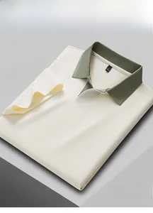 Detailed view of off-white men's Polo shirt with green contrast ribbed collar.