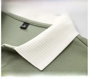 Detailed close-up view of the white ribbed contrast polo collar on a green shirt.