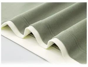 Close-up of comfortable piqué fabric hem on a green and white contrast Polo shirt.