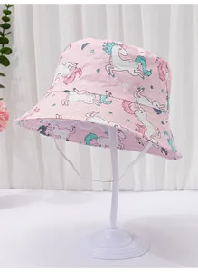 Detail of pink kids bucket hat featuring white unicorn print and windproof strap