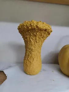 Detailed macro view of a yellow creative ceramic vase featuring a unique coral-like rough texture.