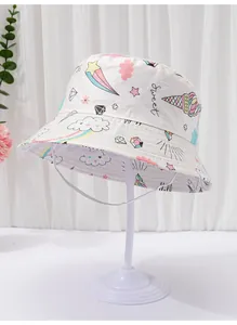 Close-up detail of white baby bucket hat with colorful unicorn and ice cream prints