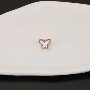 Detailed close-up of a golden butterfly stud earring featuring elegant white shell inlay