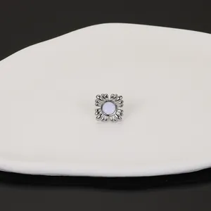 Close-up view of French style stainless steel flower stud earring with shell inlay