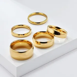 Gedetailleerd overzicht van zes gepolijste gouden titanium stalen ringen in diverse breedtes