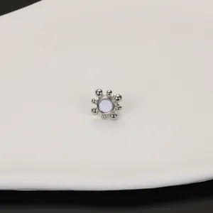 Macro view of a stainless steel stud earring with a sunburst design and shell inlay