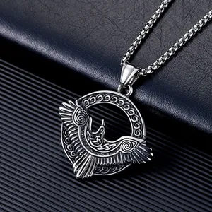Gros plan du pendentif corbeau d'Odin viking en acier inoxydable avec gravures nordiques