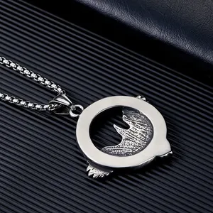 Gros plan détaillé d'un pendentif corbeau Viking Odin en acier inoxydable sur une chaîne