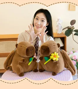 Zwei süße braune Capybara Plüschrucksäcke mit Sonnenblume und Blatt, präsentiert von Modell.