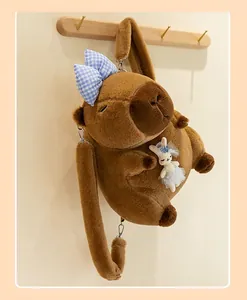 Detail of brown capybara plush backpack with cute rabbit doll and blue bow
