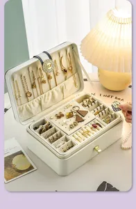 Detailed view of white multi-layer jewelry box with necklace hooks and ring slots.