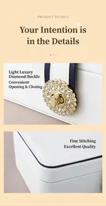 Detail view of a white leather jewelry box with a sparkling diamond-encrusted clasp.