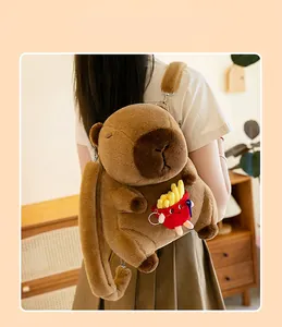 Close-up of a cute brown capybara plush backpack featuring a small french fries toy