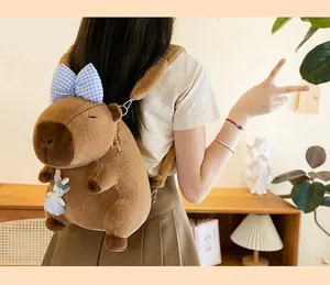 Detailansicht eines süßen braunen Plüsch-Capybara-Rucksacks mit blauer Schleifendekoration