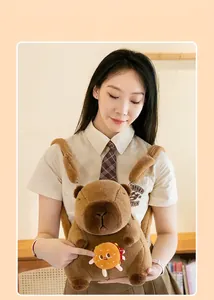 Close-up detail of a soft Capybara plush backpack with burger charm worn by a model
