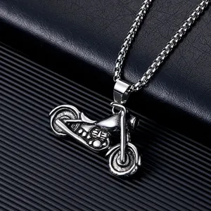 Gros plan détaillé d'un pendentif de moto vintage en acier inoxydable sur une chaîne box.