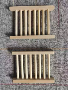 Close-up view of two natural wooden soap dishes featuring a draining rack design