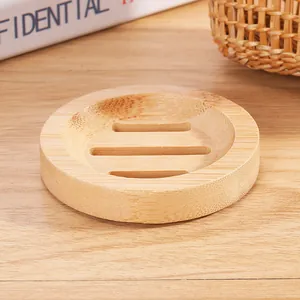 Detailed view of a round bamboo soap dish with drainage slots on a wooden surface