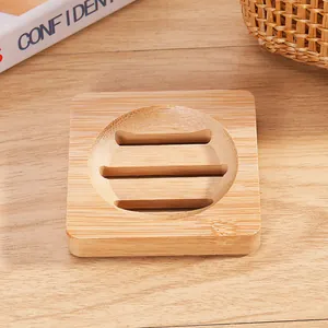 Close-up detail of a square natural bamboo soap dish featuring circular drainage slats