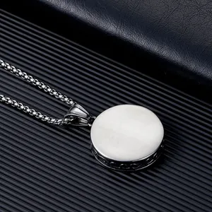 Détail d'un pendentif circulaire en acier inoxydable avec une élégante finition brossée