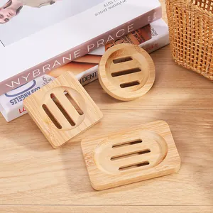 Three shapes of bamboo soap dishes on a wooden table with lifestyle props
