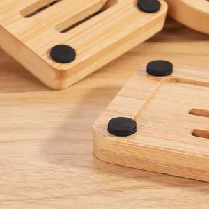 Close-up detail showing black non-slip foot pads on the bottom of a bamboo soap dish