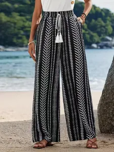Vista dettagliata dei pantaloni larghi da donna con stampa geometrica e nappine