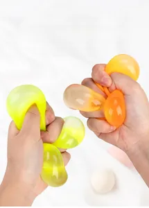 Primer plano de manos apretando pelotas antiestrés con forma de uva de colores