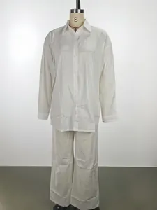 Detail of a white long-sleeved shirt and wide-leg trousers casual lounge set for women.