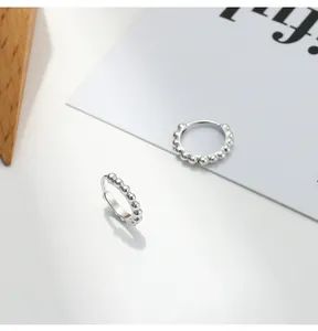 Detail view of S925 sterling silver hoop earrings with a textured beaded design.