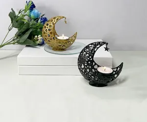Detailed close-up of decorative hollow metal moon candle holders with star pendants