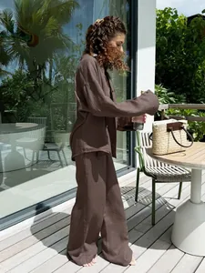 Detail shot of a woman wearing a dark brown oversized linen shirt and trousers set.