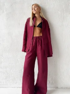 Detail view of burgundy linen long-sleeved shirt and matching wide-leg trousers set