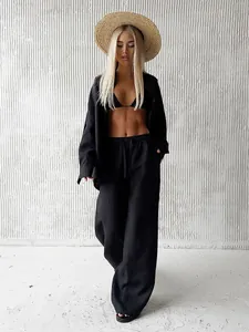 Full view of a chic black three-piece linen-look shirt and wide-leg pant set on a model.
