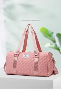 Close-up of pink quilted duffel bag with durable straps and brand label