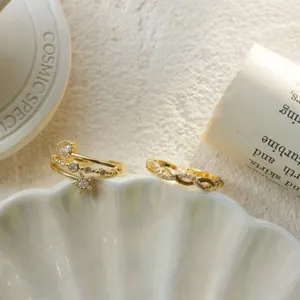 Close-up of elegant gold rings with star and twisted design on a seashell tray