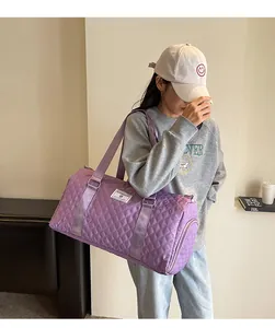 Model carrying a large purple quilted travel duffel bag suitable for sports or fitness