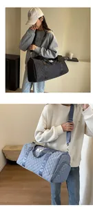 Detail view of large capacity quilted travel duffel bag carried by model in everyday setting