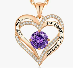 Close-up of rose gold double heart pendant with purple birthstone and engraving