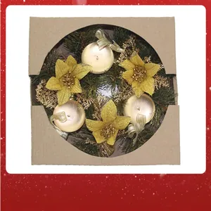 Detail view of a Christmas wreath with gold flowers in a cardboard gift box.