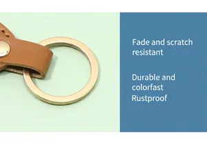Close-up view of a high-quality gold metal ring on a durable brown leather keychain strap
